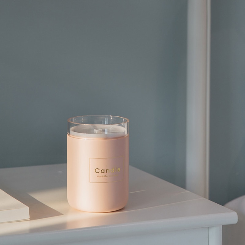 Humidificateur d'air bougie rose sur une table de chevet