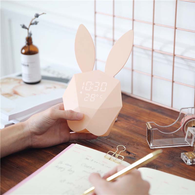 Cutty clock réveil lapin rose dans une main