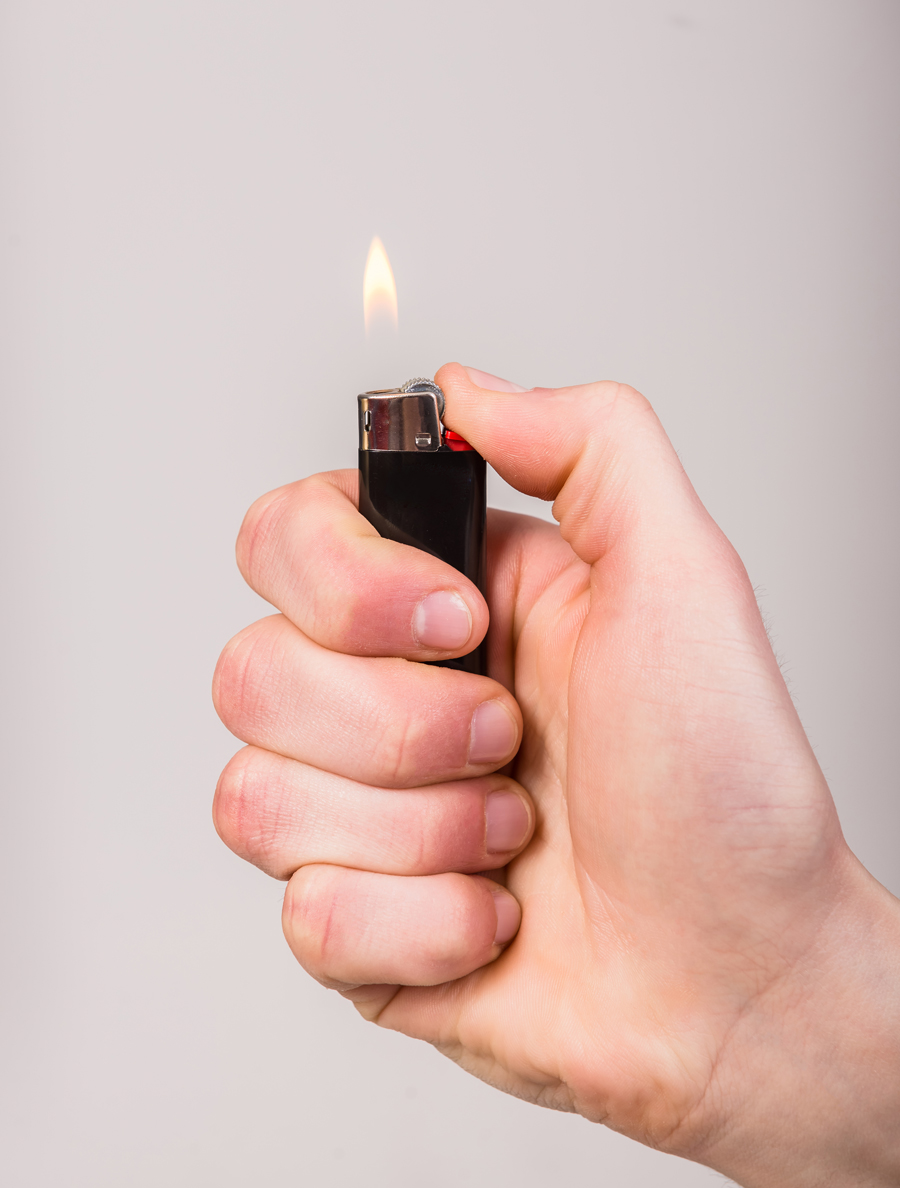 Homme qui tient un briquet allumé