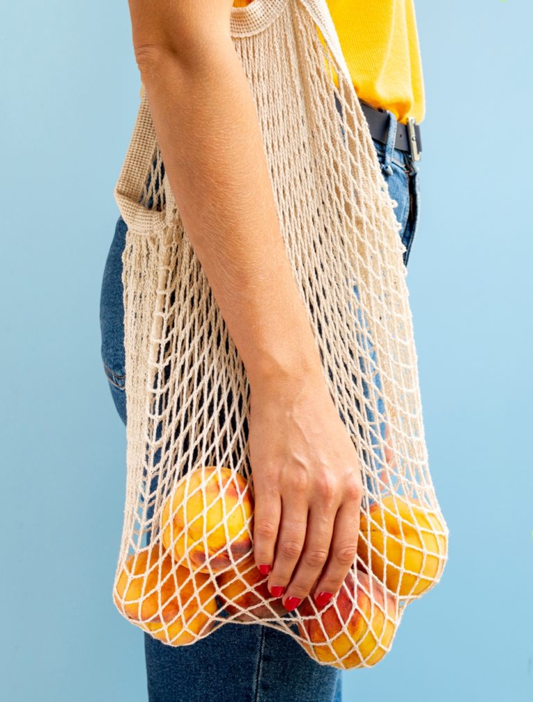 femme portant un tote bag avec des oranges