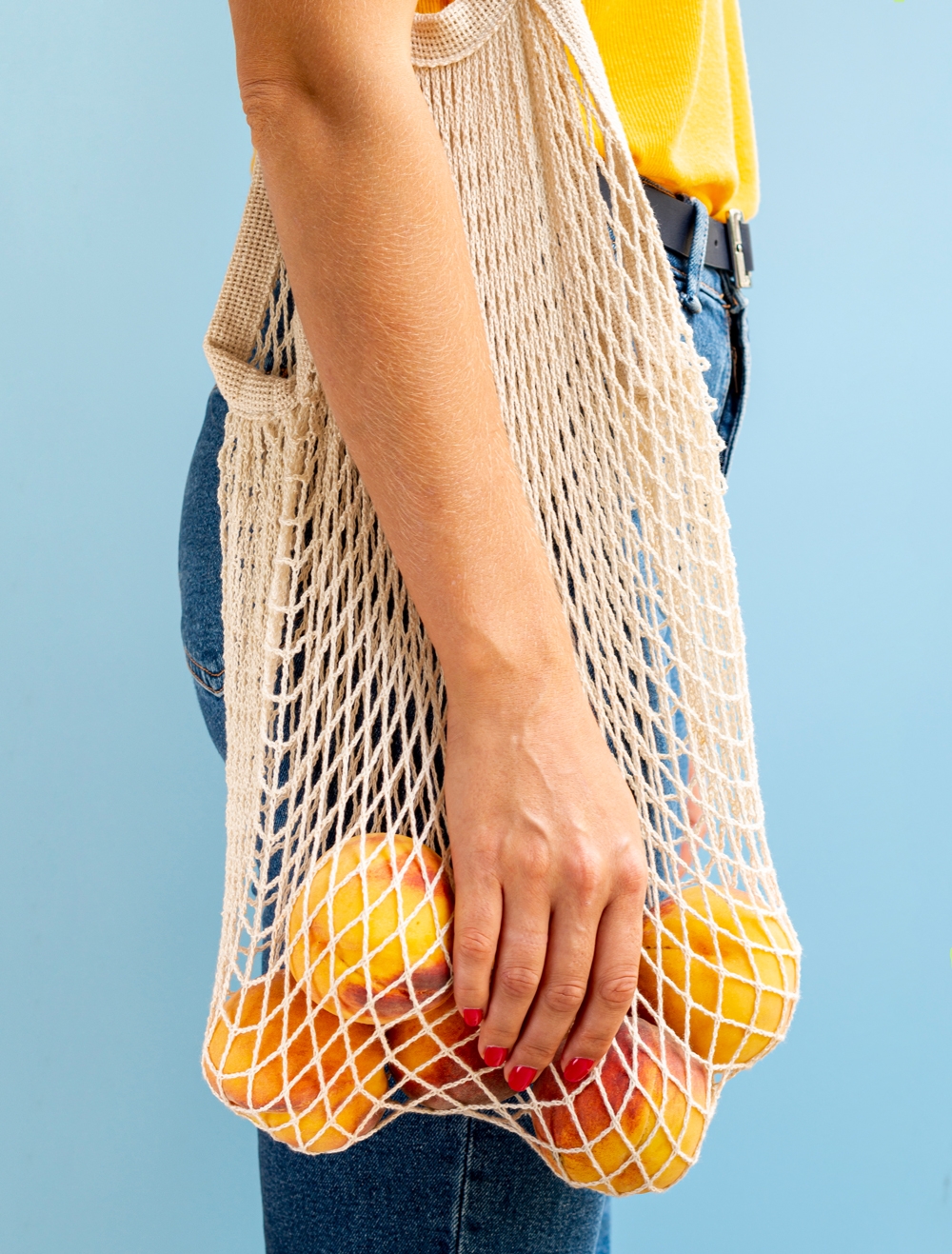 femme portant un tote bag avec des oranges