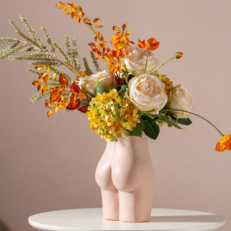 Vase fesses avec un bouquet de fleurs oranges