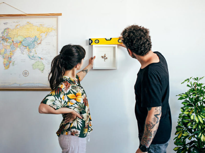 Couple qui accroche un cadre au mur