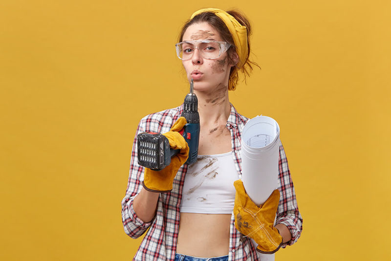 femme bricoleuse prête à percer un mur pour la décoration