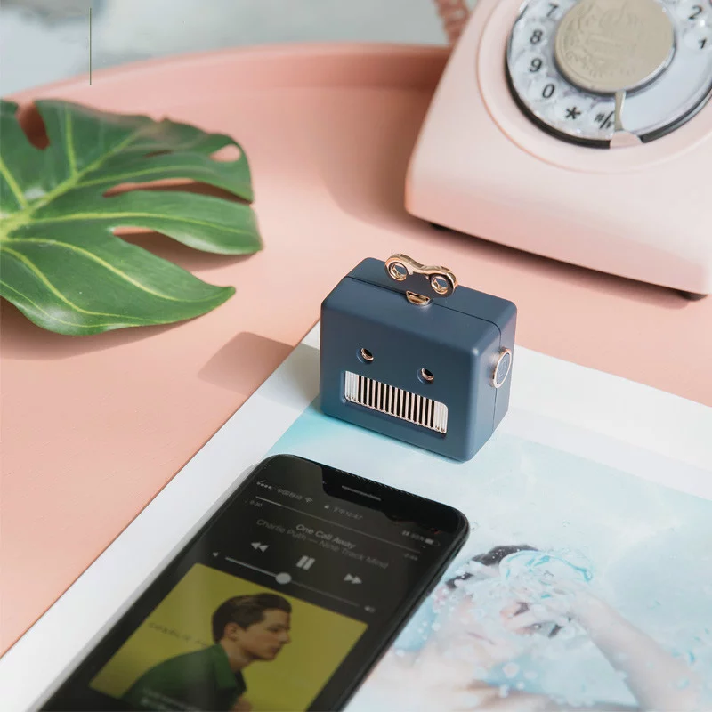 enceinte bluetooth robot bleu sur une table rose