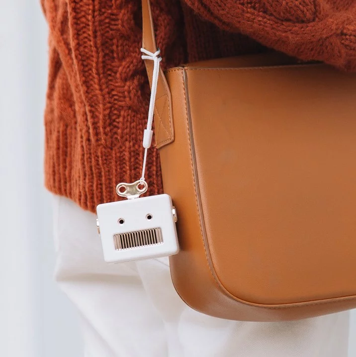 enceinte robot blanche sur un sac camel