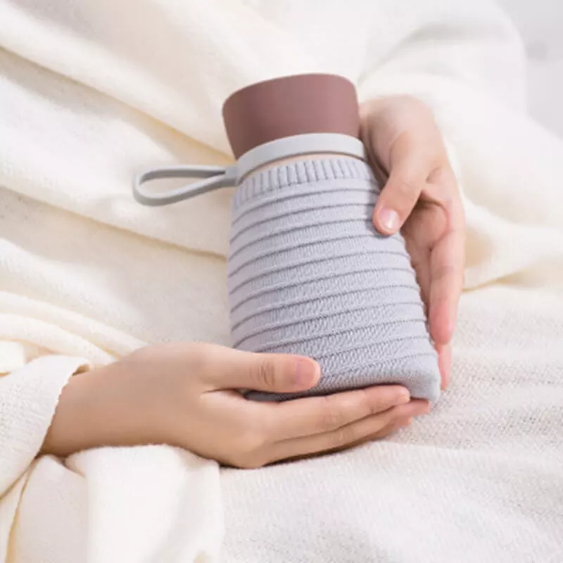 Mains qui tiennent la bouillotte bouteille