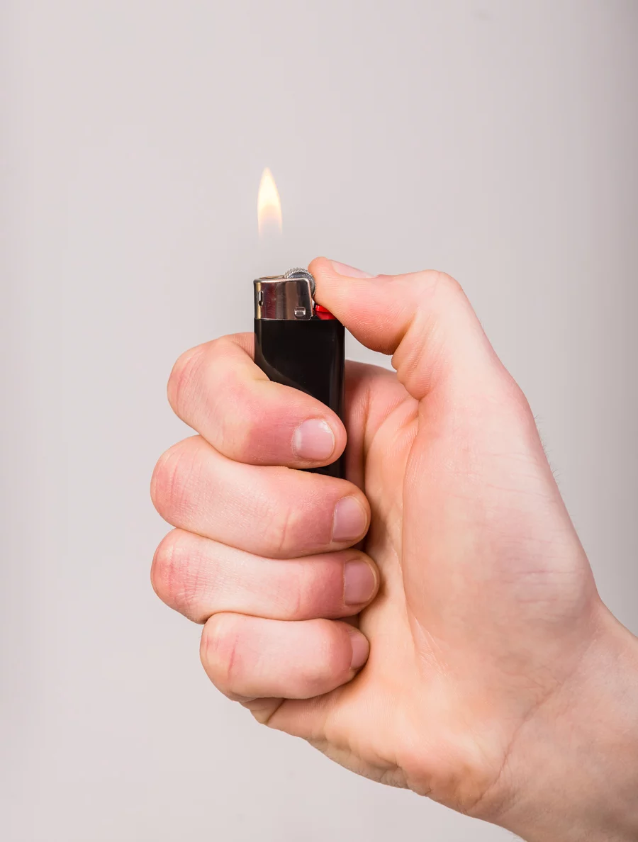Homme qui tient un briquet allumé