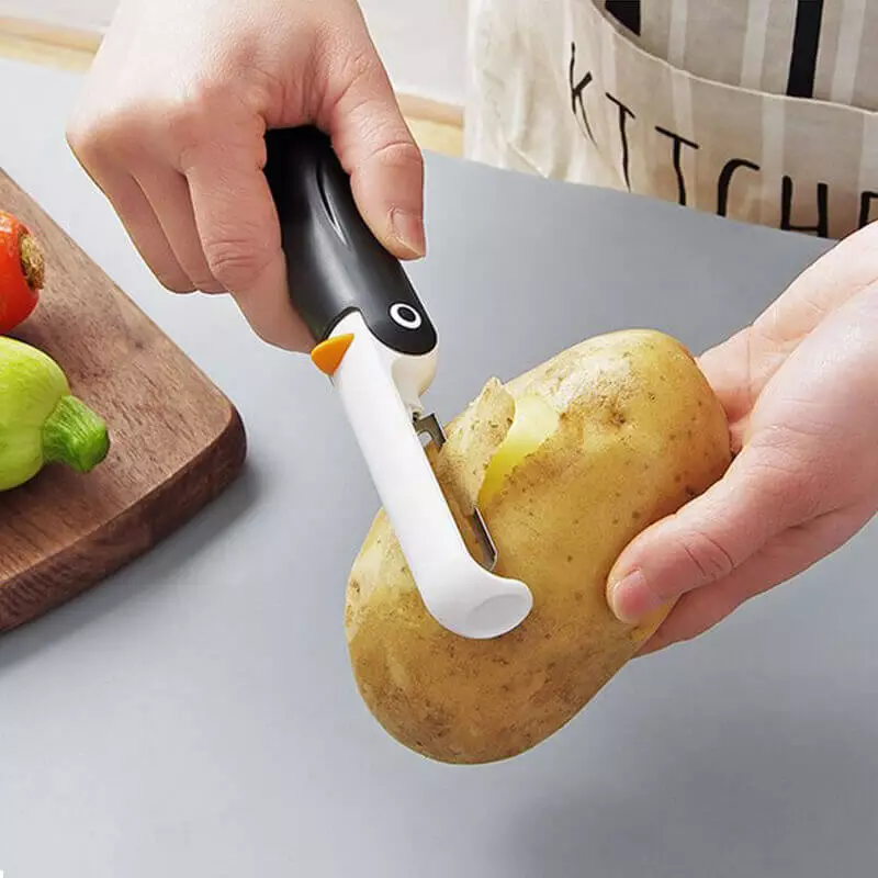 éplucheur pingouin qui épluche une pomme de terre